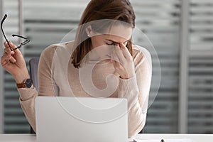 Tired businesswoman taking off glasses, massaging nose bridge close up