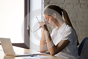 Tired businesswoman taking off glasses, suffering from eye strain