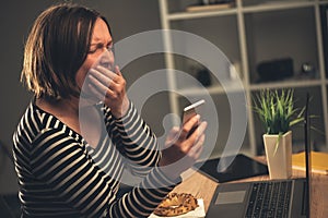 Tired businesswoman working overtime and yawning in office