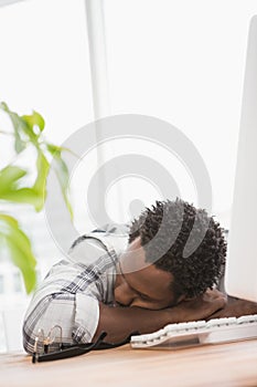 Tired casual businessman sleeping on desk