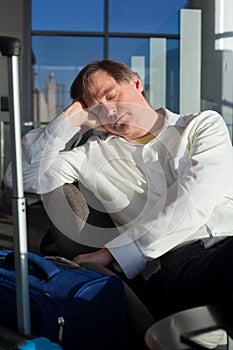 Tired Caucasian businessman sleeping at airport terminal