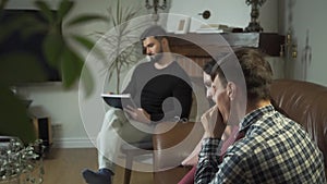 Tired Caucasian family sitting at the foreground and yawning, psychologist taking notes at the background. Young man and