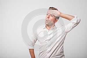 Tired caucasian man in white shirt sweating having fever headache