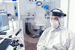 Tired chemical engineer in protection suit against infection photo