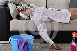 Tired from cleaning girl lies at home on couch