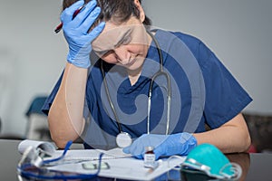 Tired and confused doctor writing prescription during novel coronavirus COVID-19 pandemic