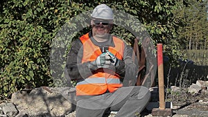 Tired construction worker struggling with sleep near a pile of bricks