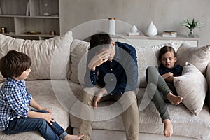 Tired dad and bored sibling kids going through conflict