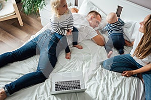 Tired dad trying rest while his mother and children playing