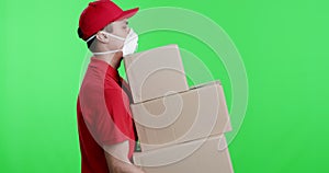 Tired delivery man in protective mask walking with heavy parcels