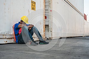Tired  depressed black foreman worker working at Container cargo harbor to loading containers. African dock male staff fall asleep