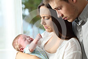 Tired desperate parents and baby crying photo