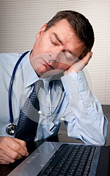 Tired doctor sleeps at desk