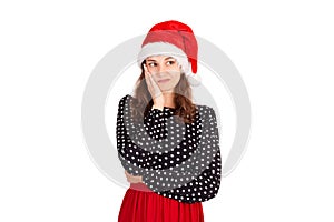 Tired dreamy and gloomy womanin dress, leaning on palm and gazing up, thinking. emotional girl in santa claus christmas hat isolat