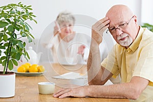 Tired elderly man arguing with his wife in the morning