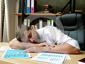 A tired employee sleeps at the table. Chronic fatigue syndrome.