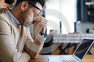 Tired exhausted business man, office worker, manager or freelancer, sitting at his desk