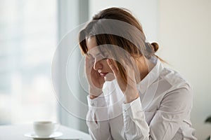 Tired exhausted businesswoman feeling strong headache at work to