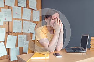 Tired exhausted female freelancer working from home