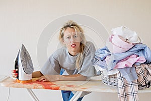 Tired and exhausted woman at ironing desk