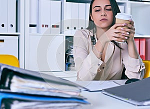 Tired and exhausted woman looks at the mountain of documents. Deadlines for the submission of reports.