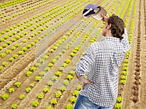 Tired Farmer Wiping Sweat And Contemplating Plants In Greenhouse