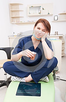 Tired female dentist doctor taking a coffee break