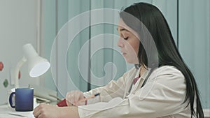 Tired female doctor sits in a medical office in