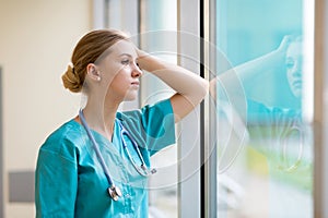 Tired female nurse in hospital corridor