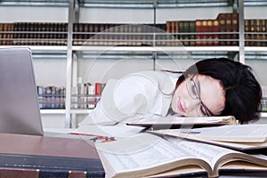 Tired student fell a sleep in a library