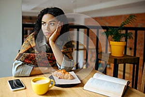 Tired female student at the table in cafe