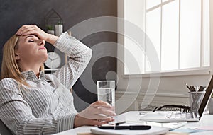 Tired financial adviser with headache at office