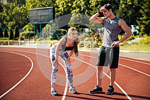 Tired fitness couple of runners at the stadium