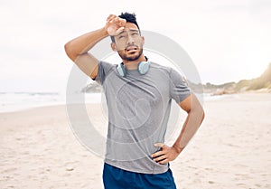 Tired, fitness and man on a beach taking a break after workout for active lifestyle. Exercise, natural ocean and male