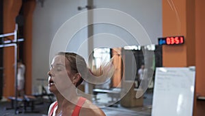 Tired fitness woman doing double jumping rope workout in gym