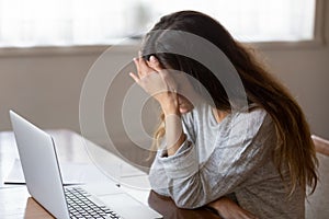 Tired girl having painful feelings due to computer overuse.