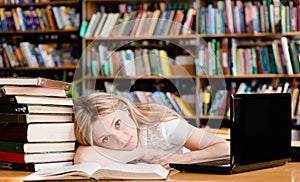 Tired girl in the library teaches before exams