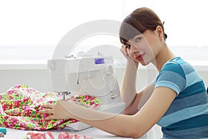 Tired girl seamstress and sewing machine