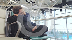 Tired girl teen traveler sleeping on the airport waiting for the plane departure gates bench with all her luggage