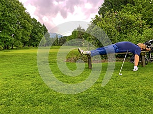 Tired Golfer Sleeping on a Bench on Golf Course