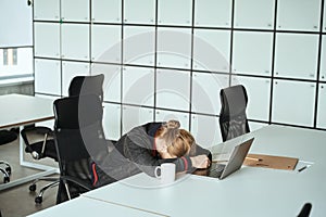 Tired guy dozed off at the laptop at the workplace