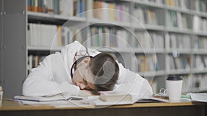 Tired guy falls asleep while studying At Library At College