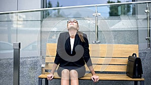 Tired but happy business woman sitting on bench, successful contract, hard work