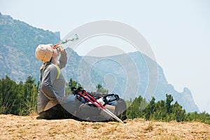 Tired hiker drinks water