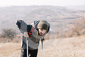 Tired hiker man resting on hiking poles