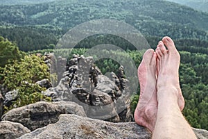 Tired hikers legs without shoes. Naked legs on peak photo