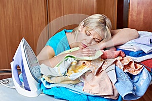 Tired housewife sleeping on an ironing board