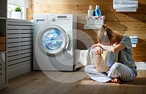 Tired housewife woman in stress sleeps in laundry room with wash