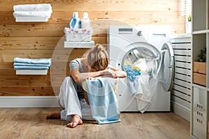 Tired housewife woman in stress sleeps in laundry room with wash