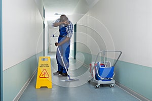 Tired Janitor Cleaning Floor